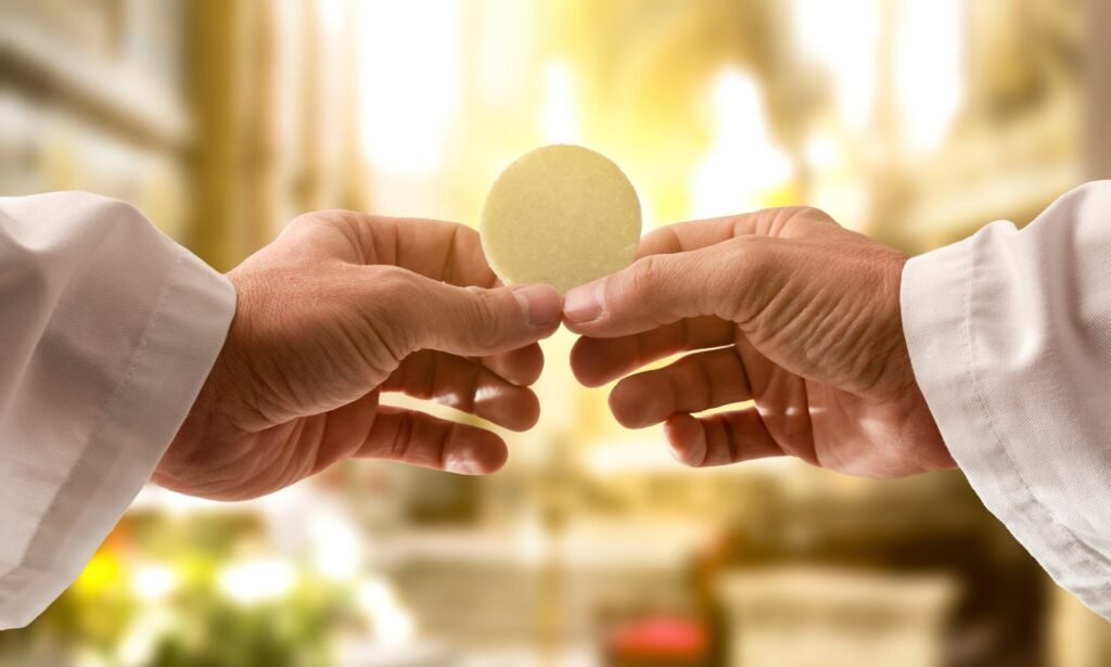 hands of a priest consecrating a host in the church