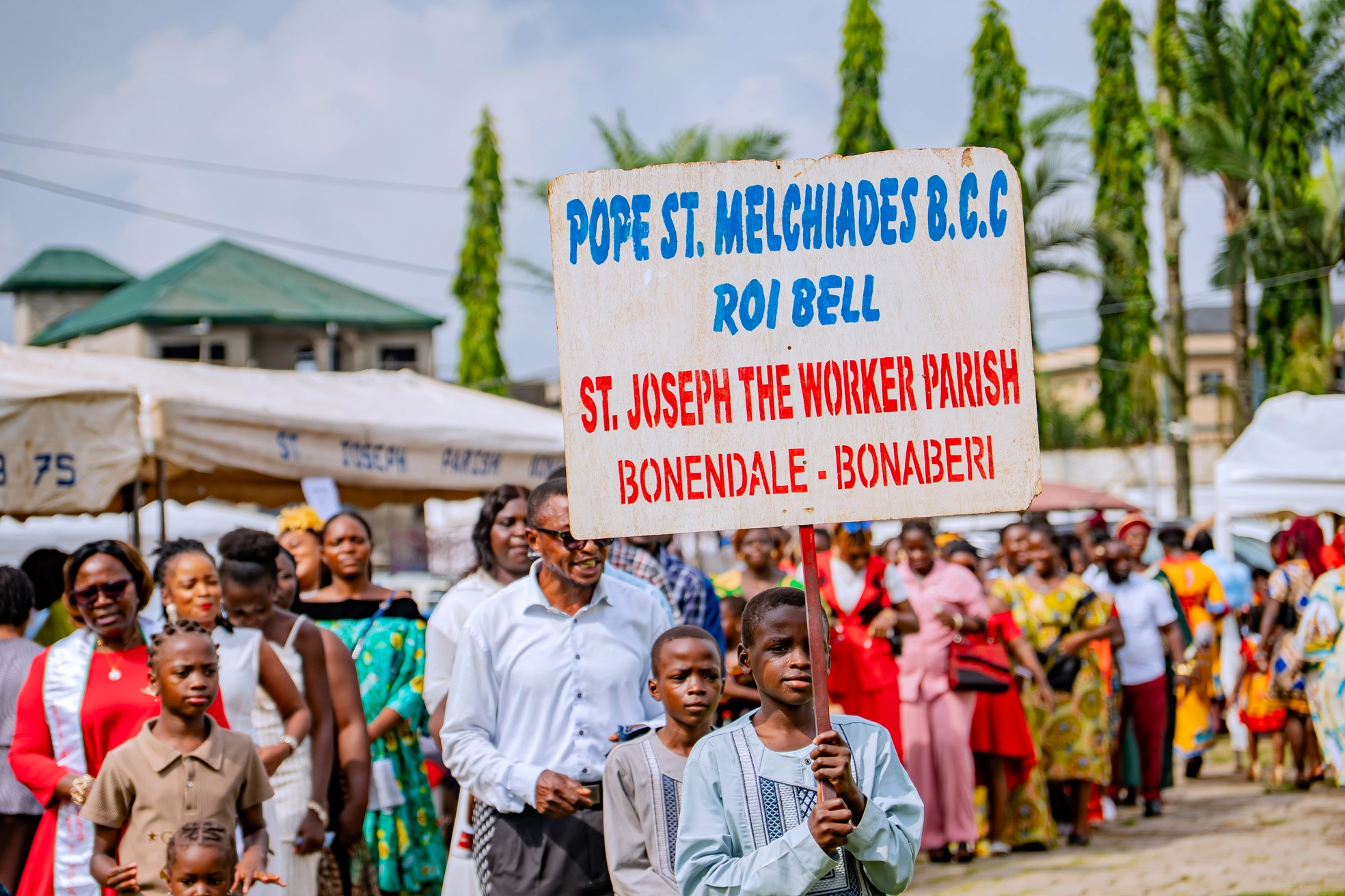 Long procession of parishioners in colourful uniforms
