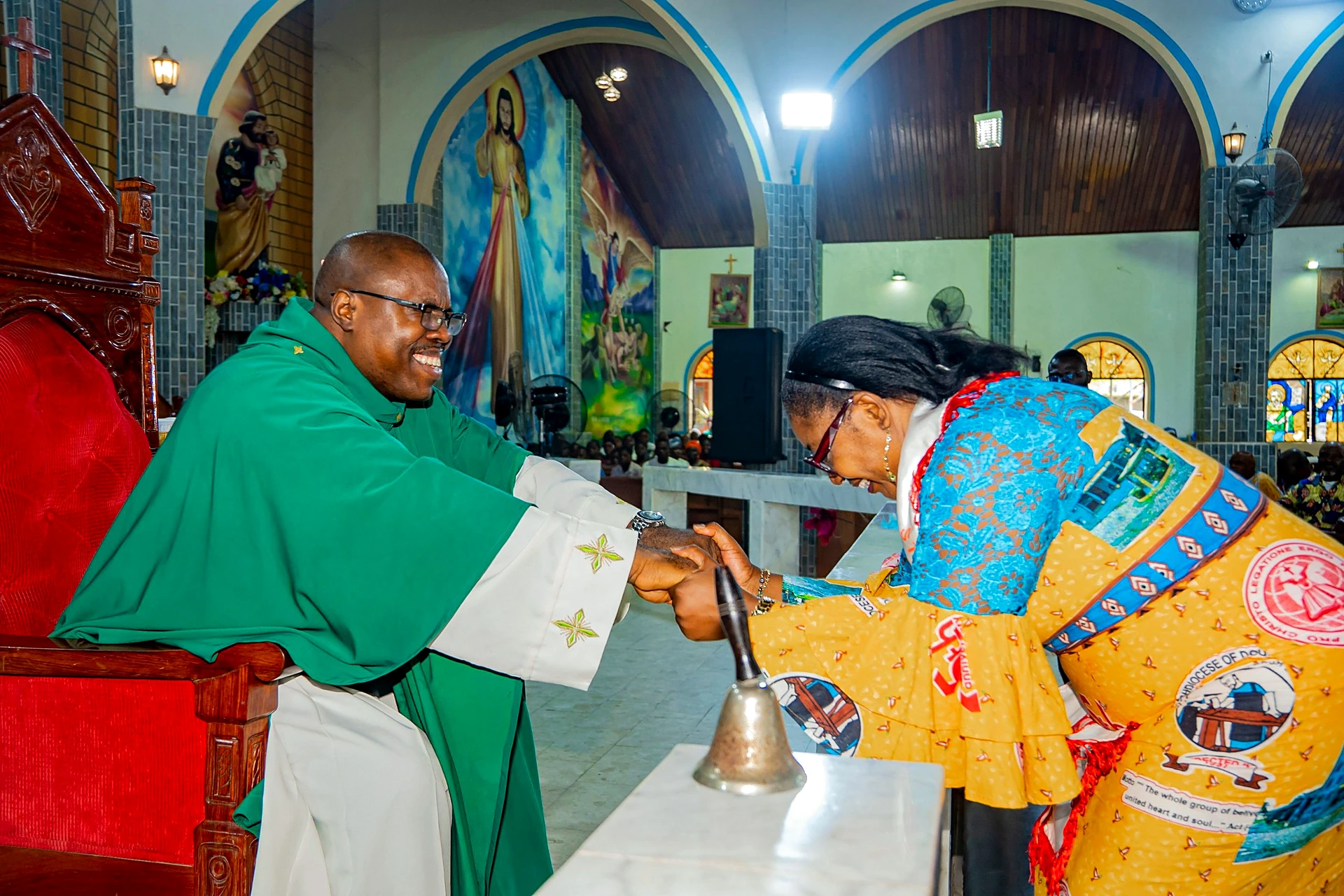 Fr. Mark Ameh Installed as Parish Priest of St. Joseph the Worker, Bonaberi Madam Evangeline Etaka, Chairlady of the EAC, greets Fr. Mark