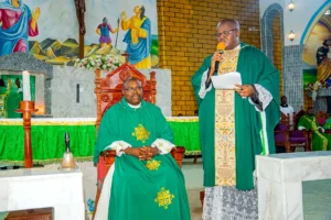 installation fr mark seated monsignor choumbo speaking