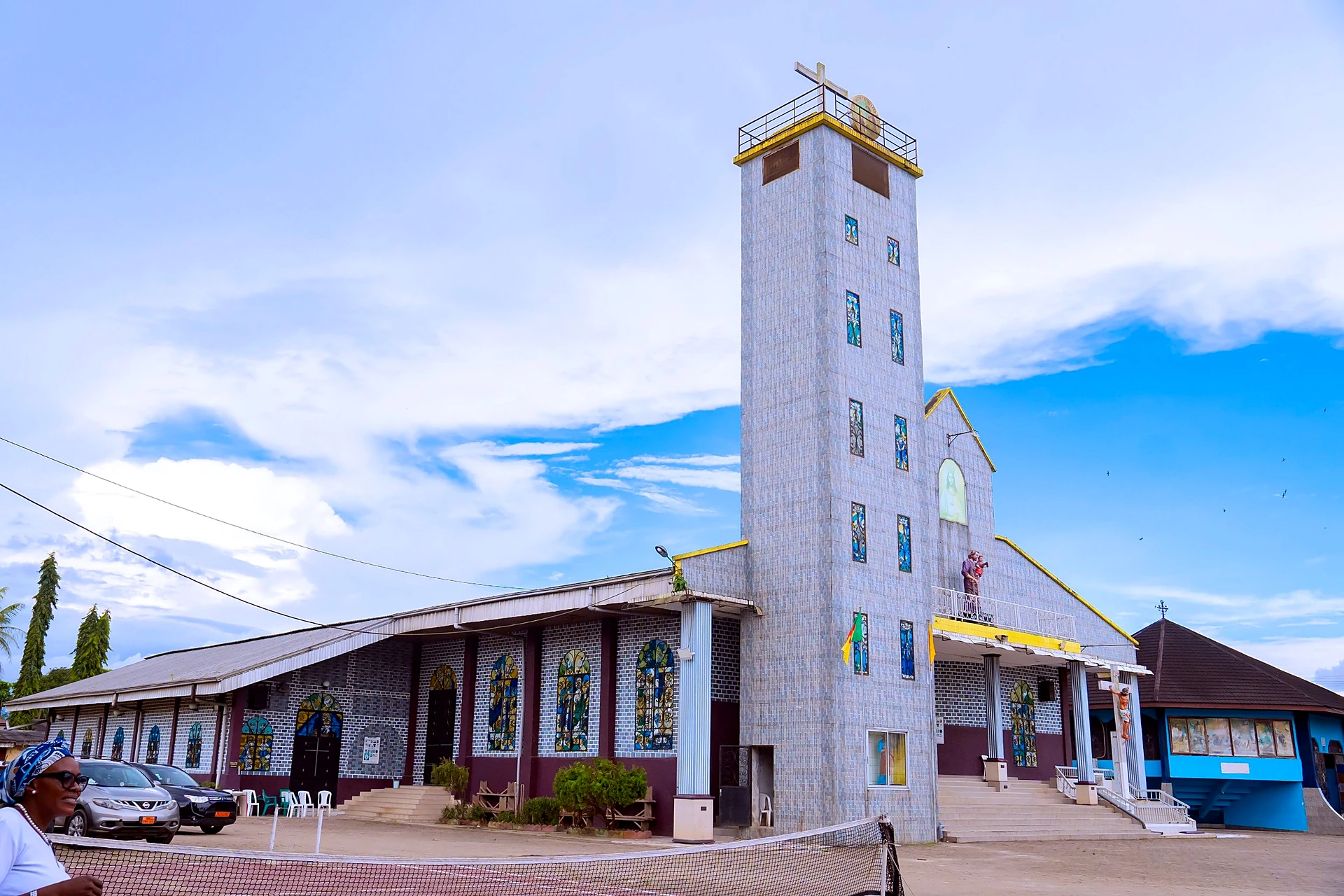 The church of St. Joseph the Worker Parish, Bonaberi, with its tiled bell tower under a blue sky